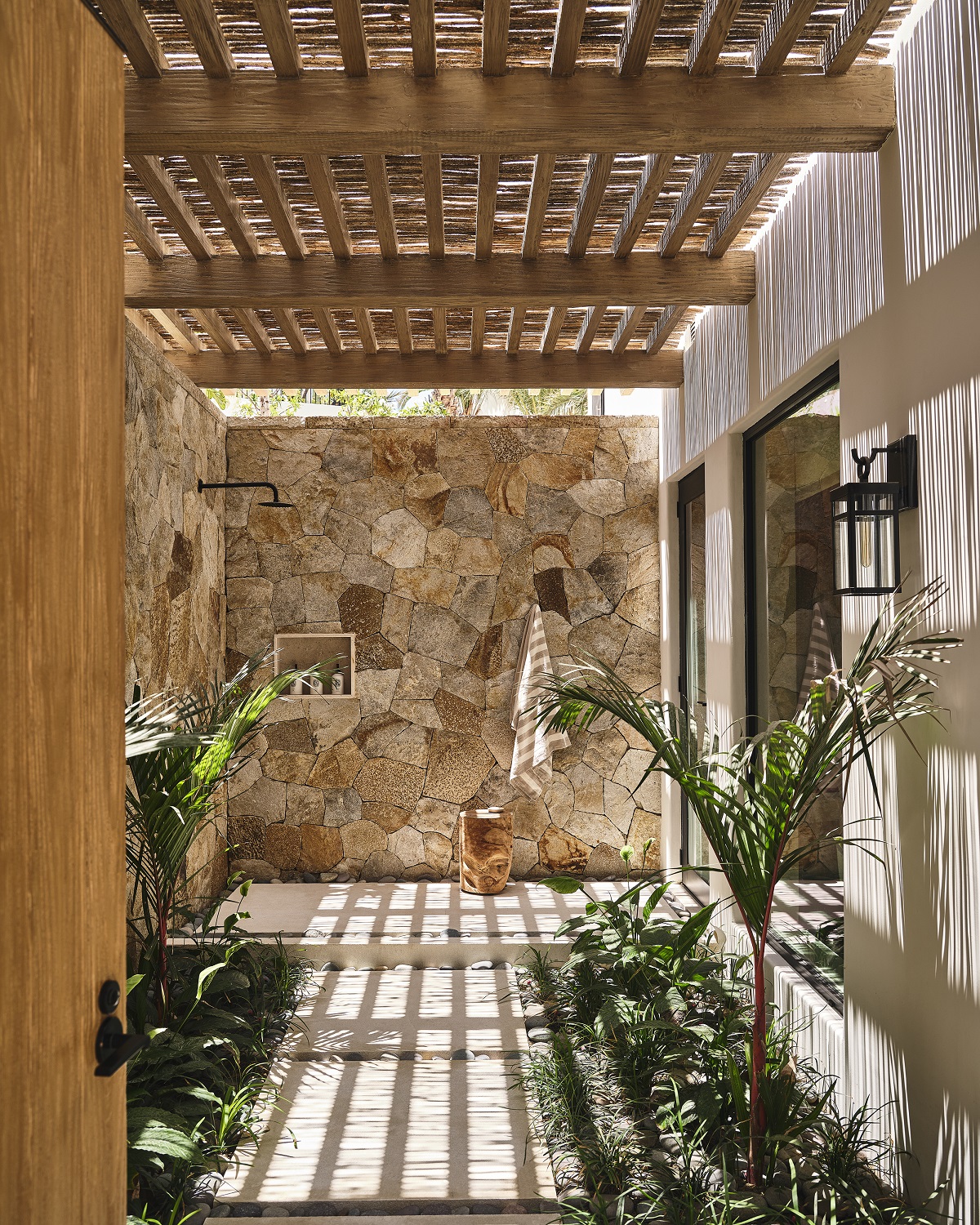 outdoor shower with plants and wood and stone surfaces