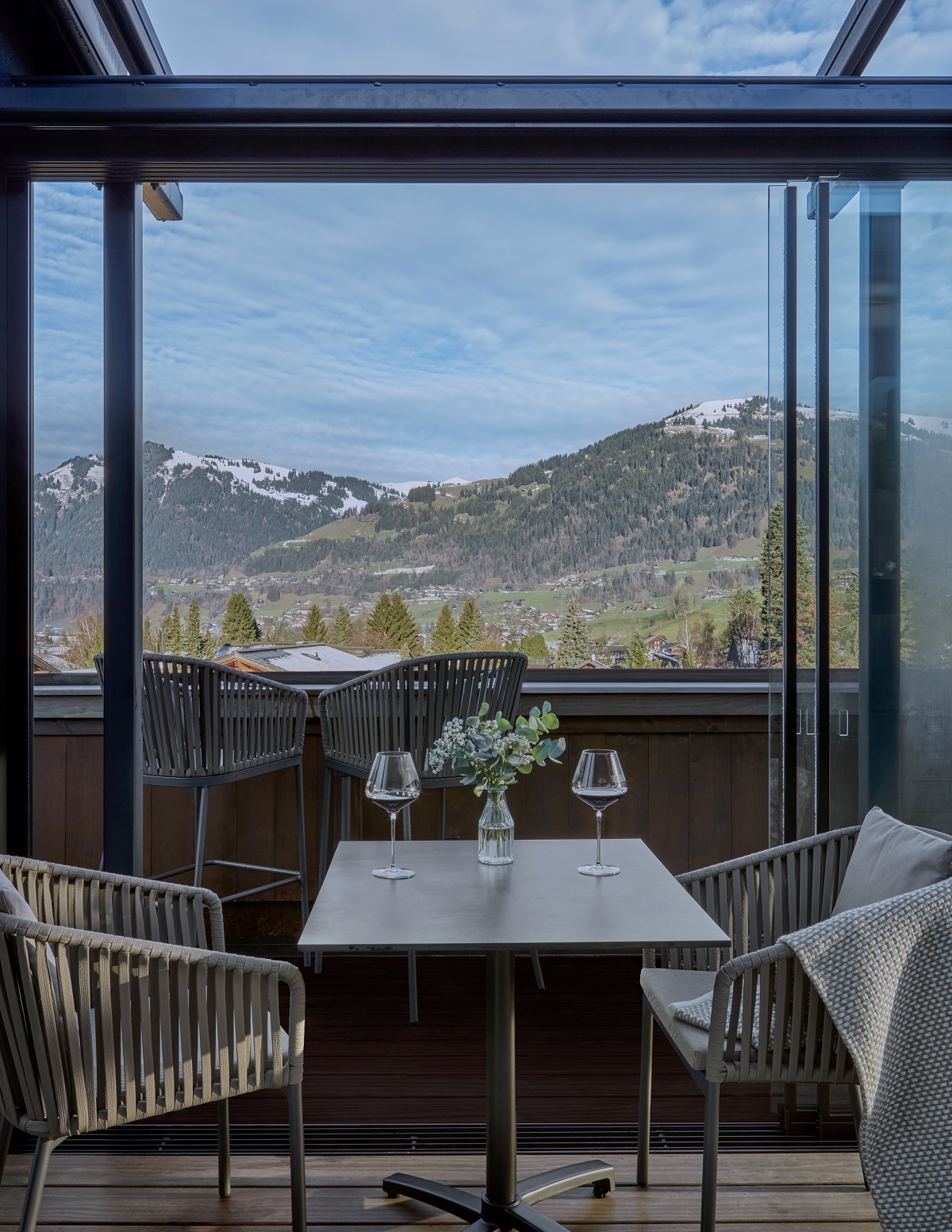 chair and table at rooftop bar with mountain view at The Mansard in Gstaad