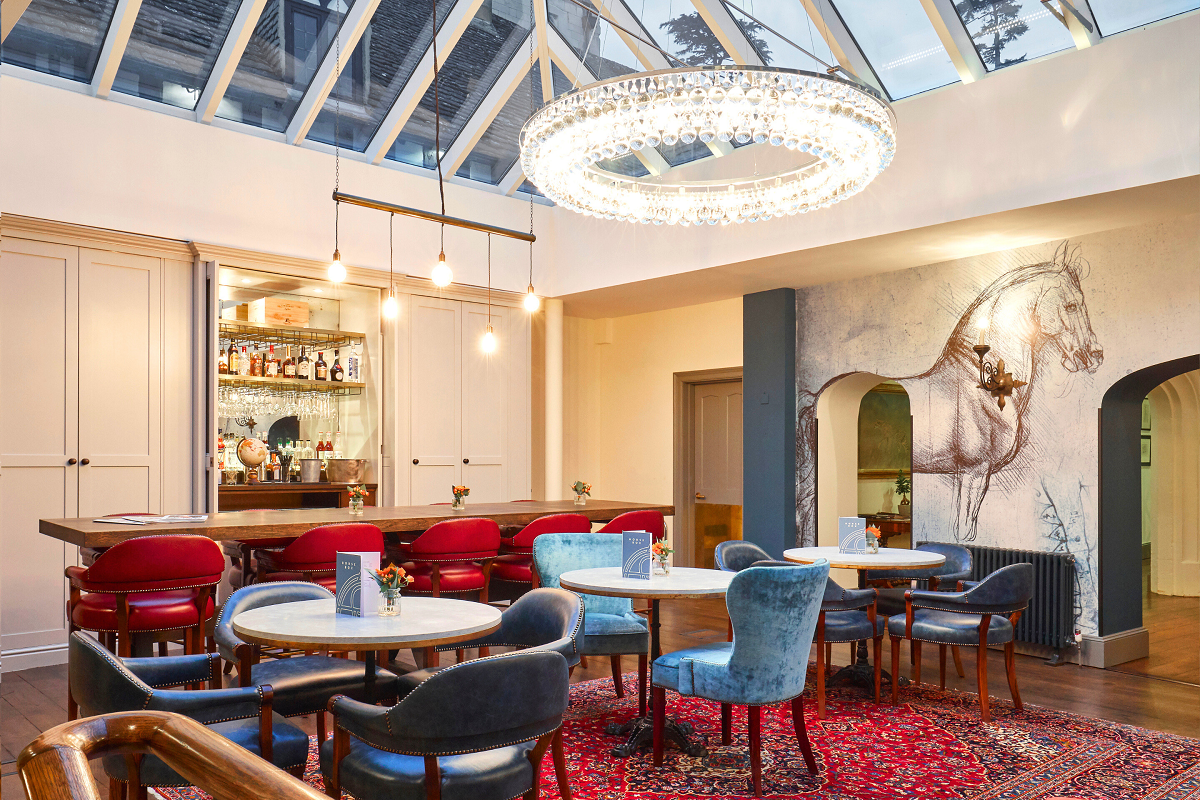 bar under glass roof with horse mural and contemporary chandelier style light