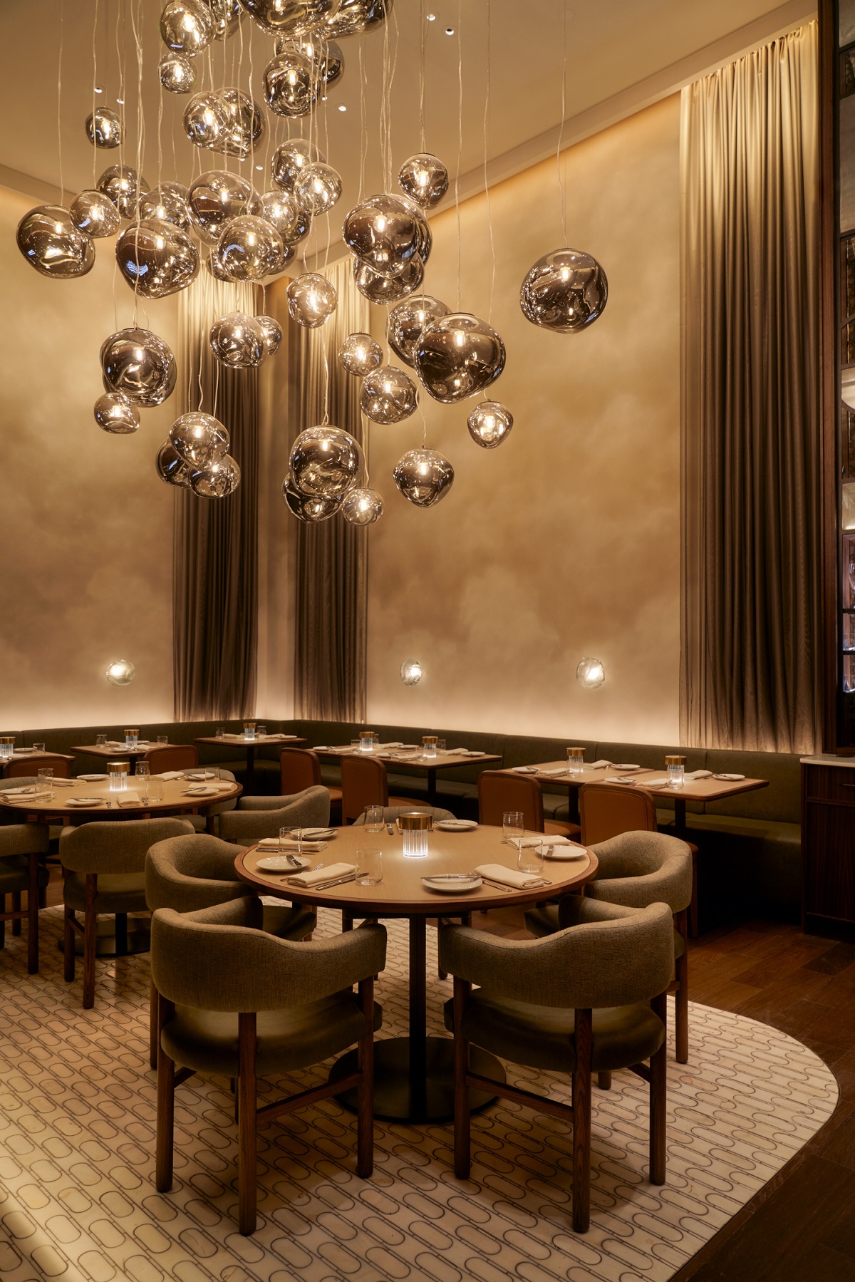 cascading silver bauble chandelier lighting above diners table in Santi Manhattan