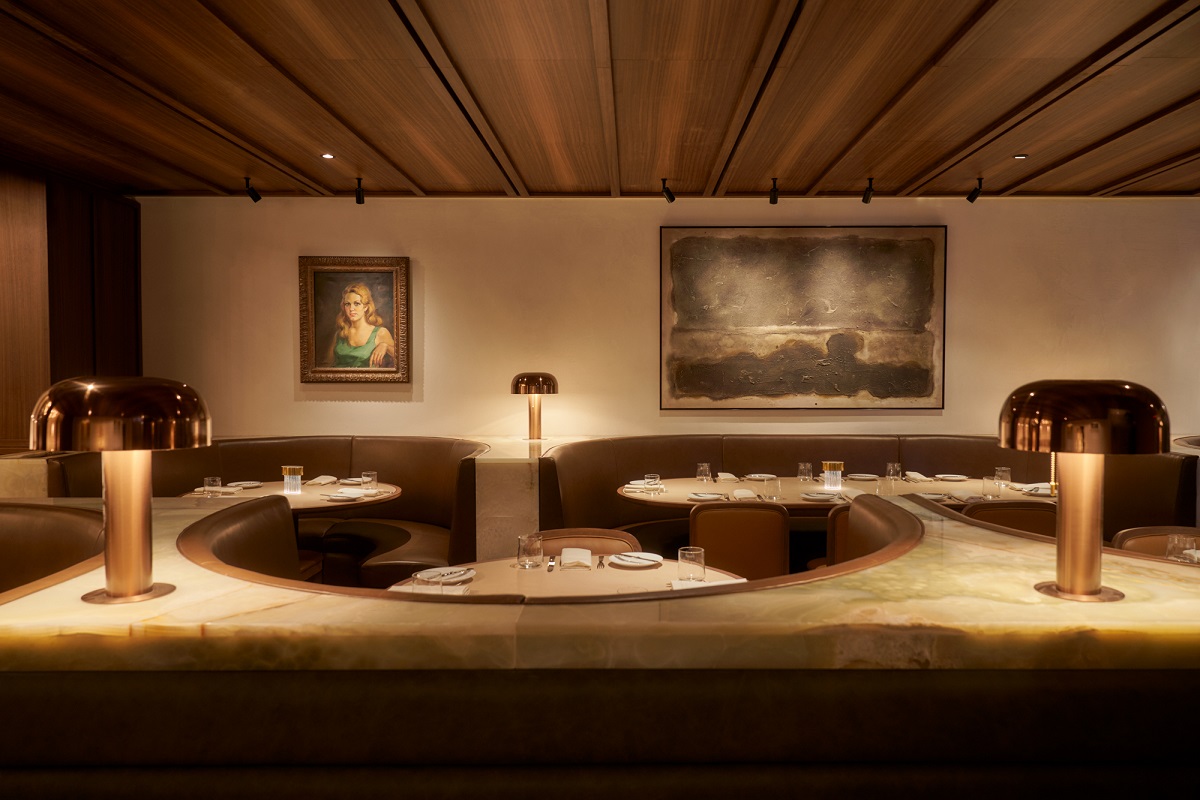 curved banquette, low lighting and curated art in Santi