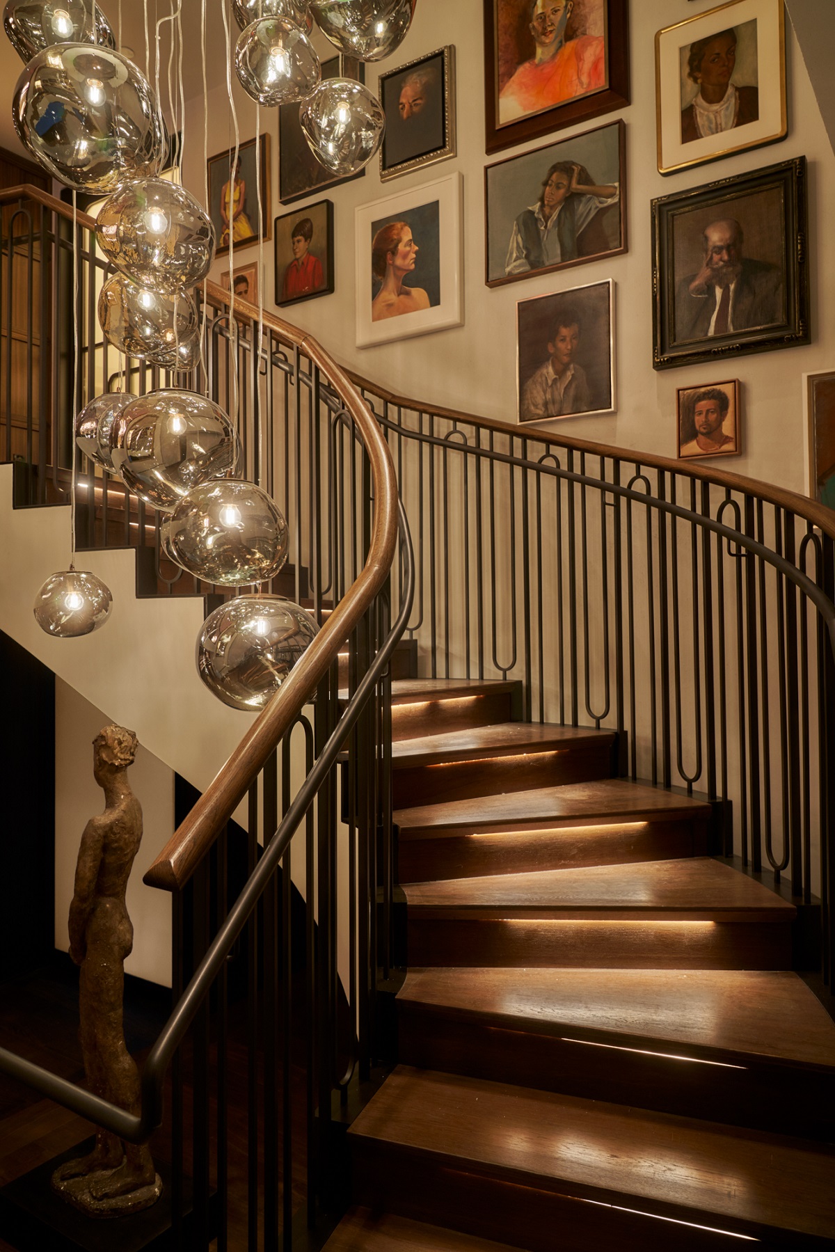 staircase in Santi with silver lighting baubles and art gallery wall