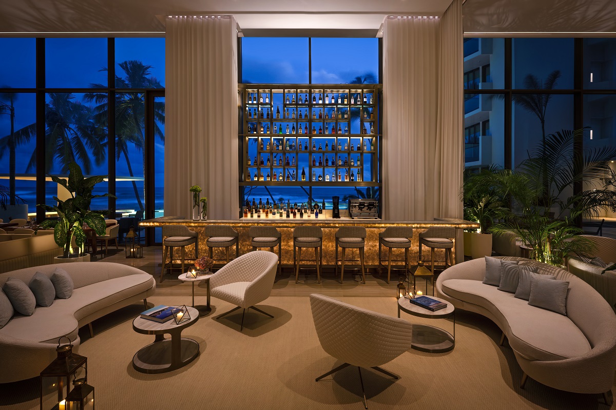 chairs and couch in front of the bar with bar shelving in the window