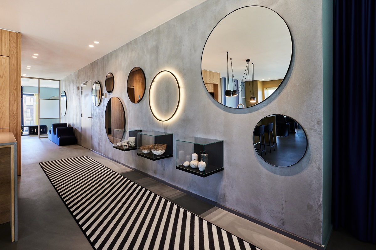 mirror collection on walls of entrance to Kirk Suites with striped Ege carpet on the floor