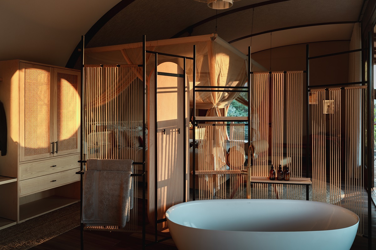 wooden surfaces and bamboo screens in ensuite bathroom with free standing bath