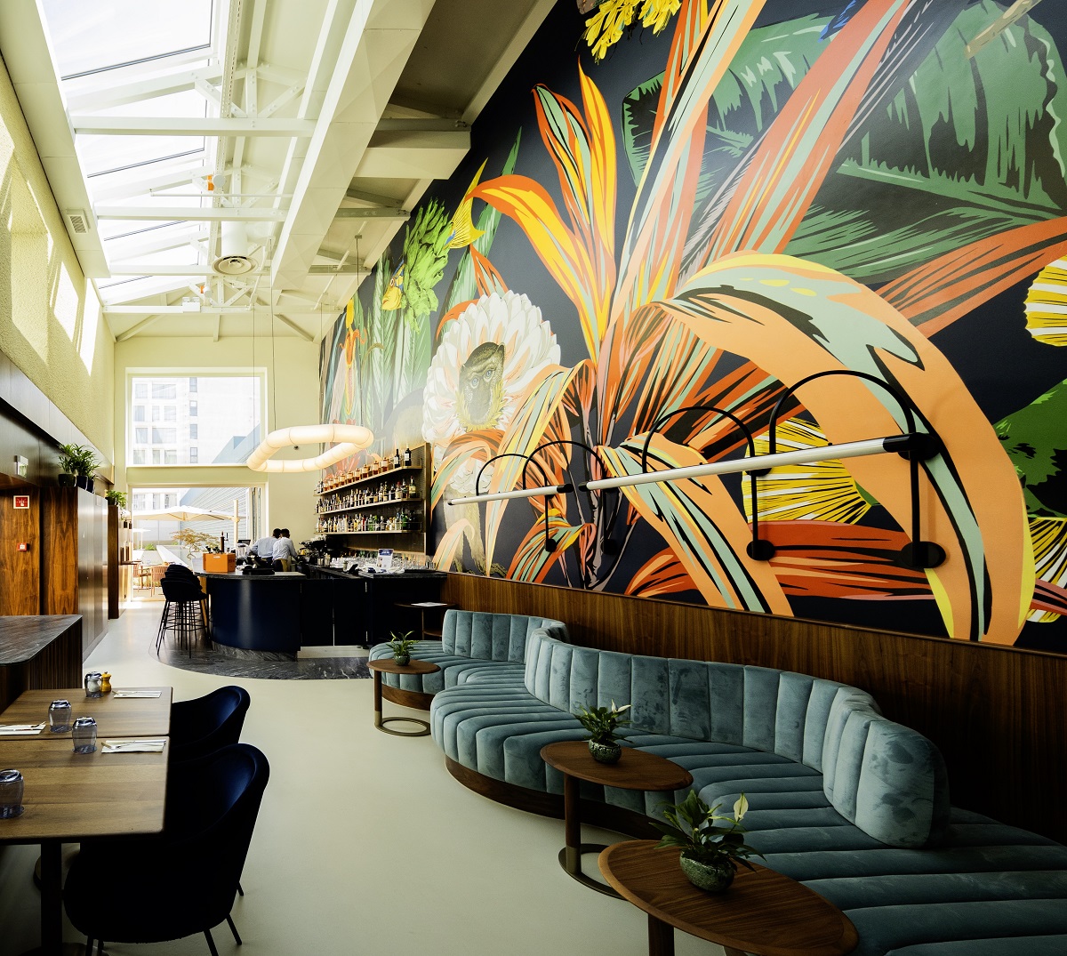 tropical mural above curved green banquette in Lisbon hotel by S+A architects