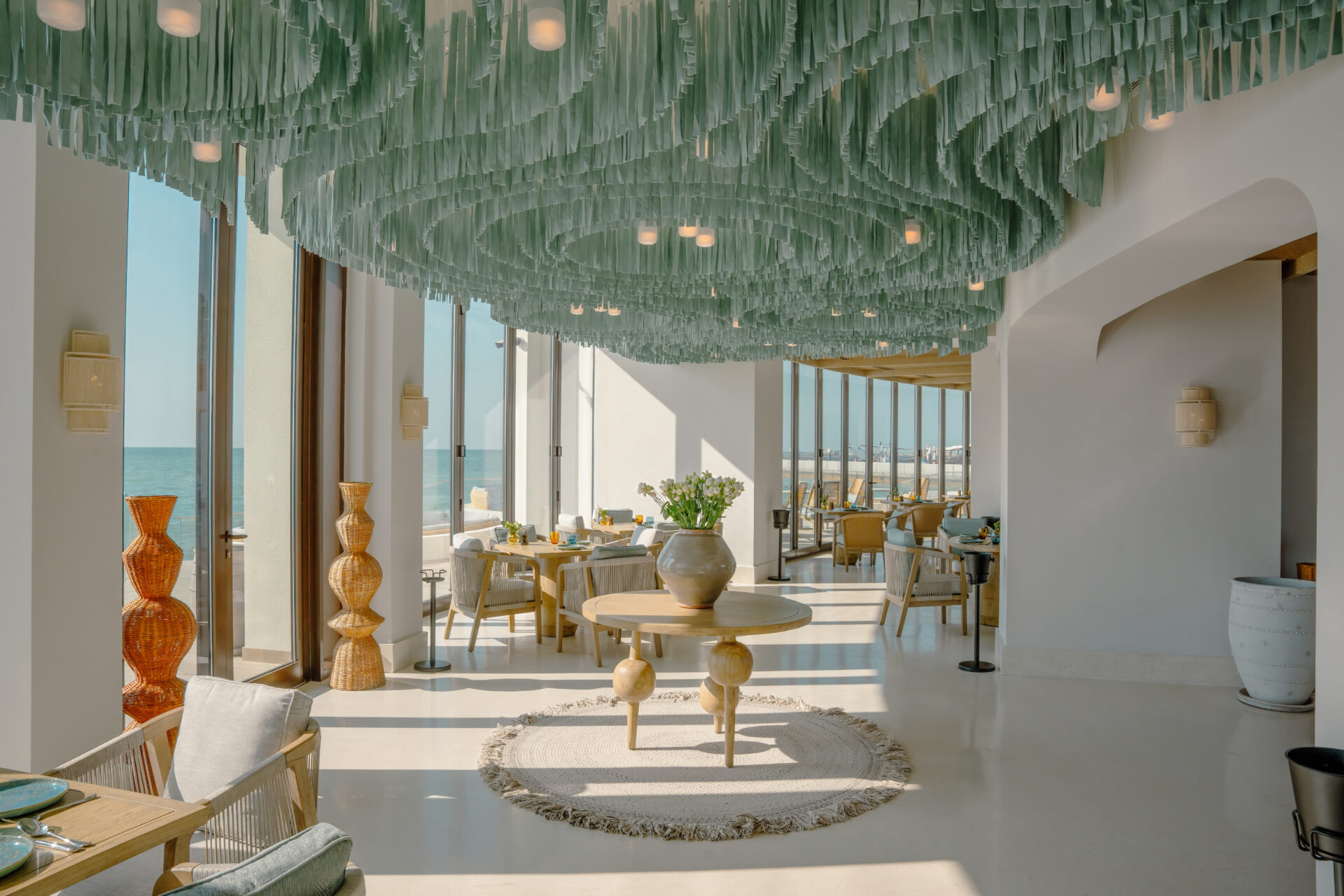 February hotel opening - Hawar Resort by Mantis C-Salt restaurant with green glass wave-like ceiling artwork