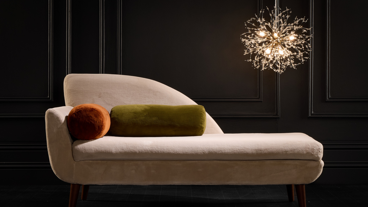 cream velvet couch under chandelier with velvet cushions