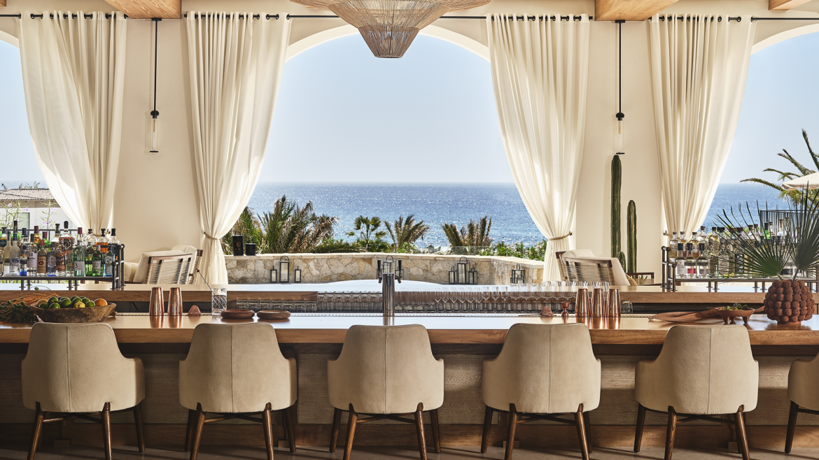 chair looking out across table and drapes to pool and sea at Four Seasons Cabo design by Meyer Davis