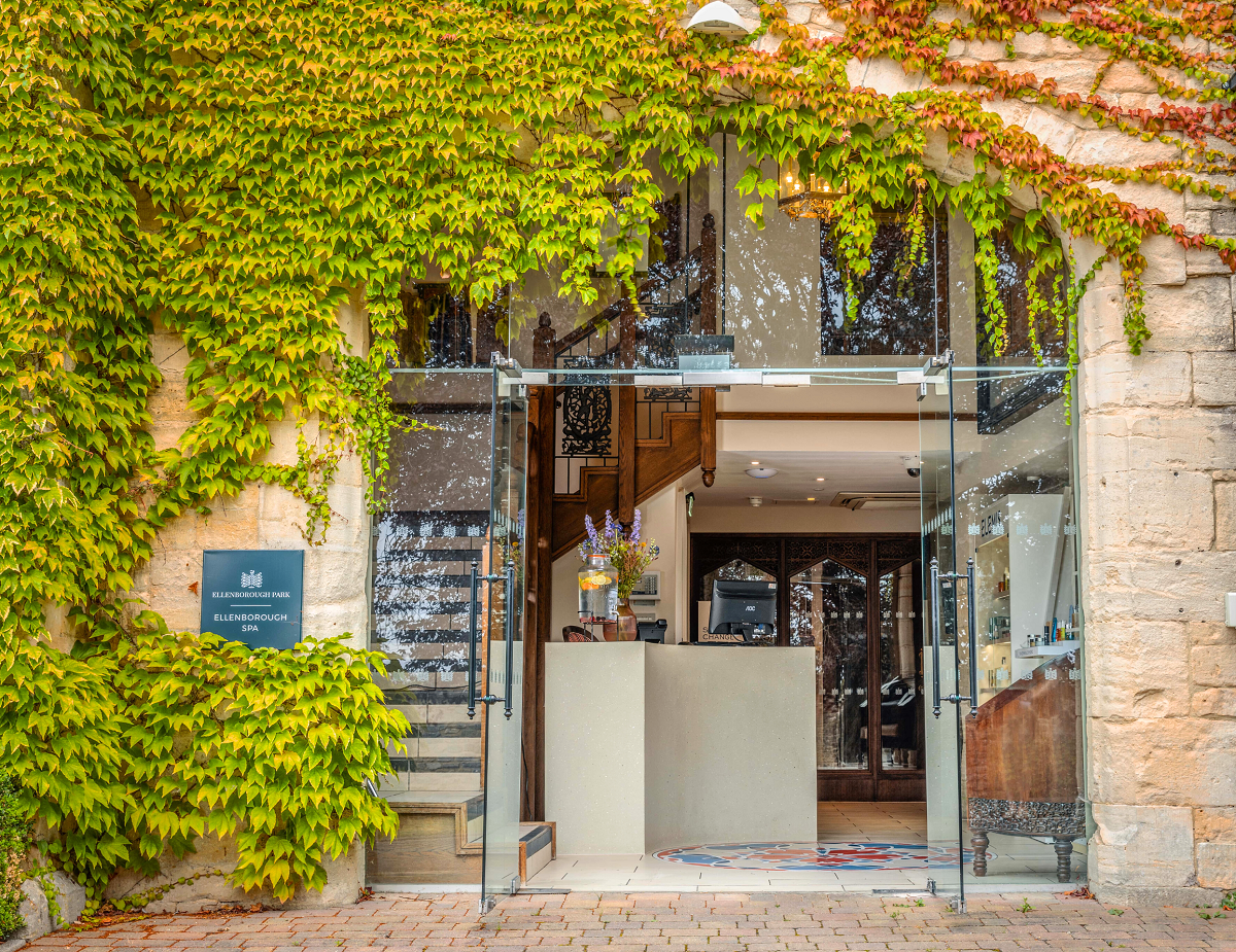 stone and ivy clad walls with glass door at hotel entrance