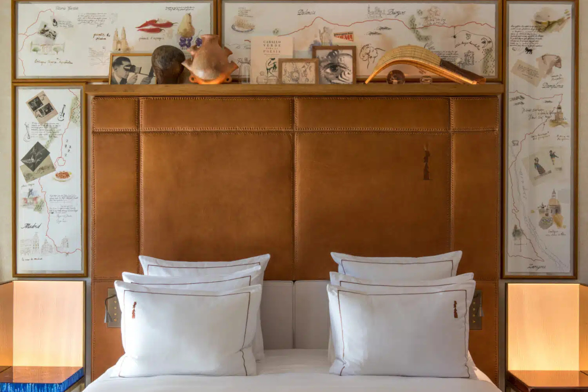 Leather bed headboard covered in travel trinkets, sketches and images in the Brach Madrid