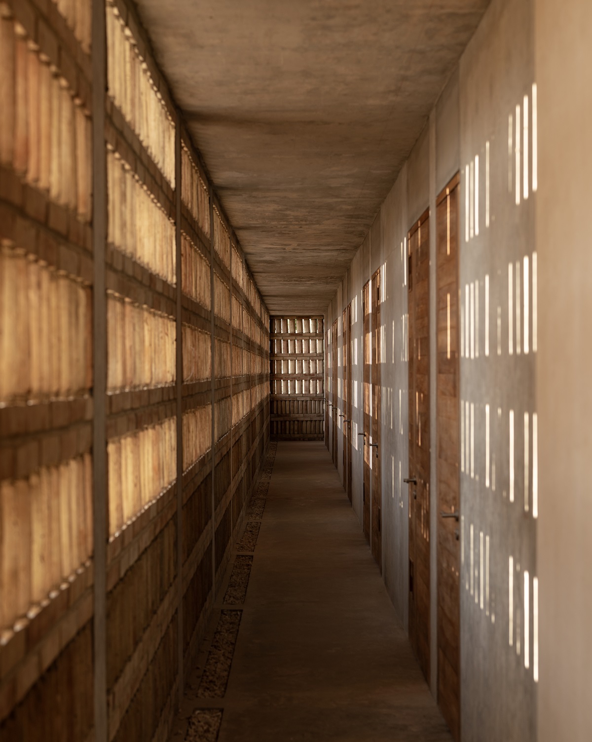 corridor with slatted sunlight through concrete shutters in Hotel Humano