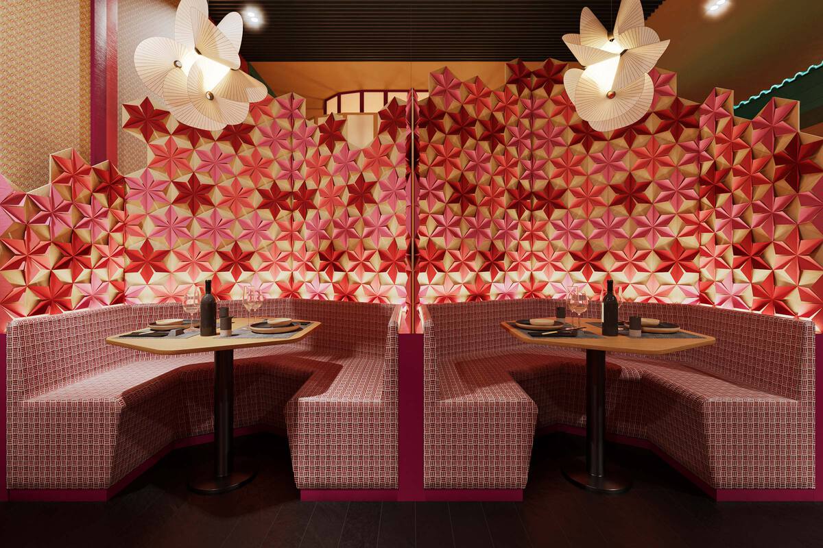 Pink hued restaurant setting, with a pink and red star-shaped origami background, and pink curved booths