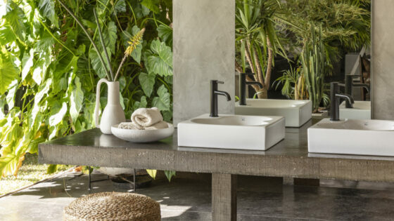 Double Ohtake basins in outdoor bathroom area, greenery surrounds