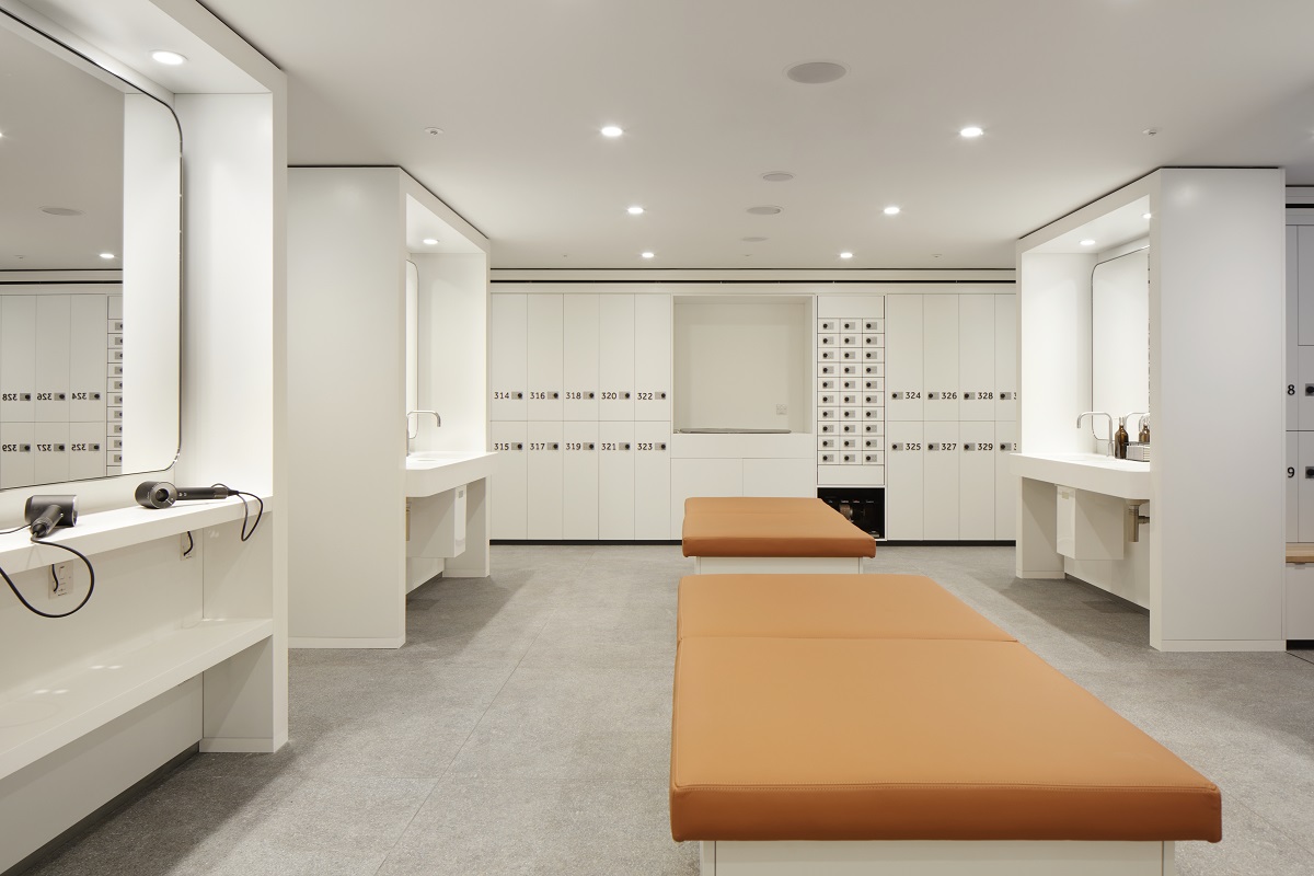 orange benches in the middle of changing room with lockers and mirrors