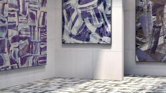 Grey graphic carpet in art gallery space, surrounded by blue graphic art