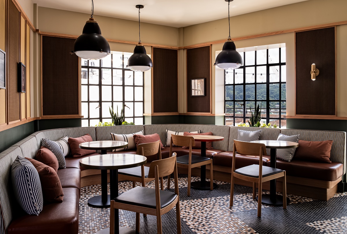 industrial style windows in restaurant with banquettes and round tables