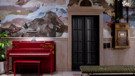 red piano and hand painted wallpaper in the lobby of Asheville Flat Iron Hotel