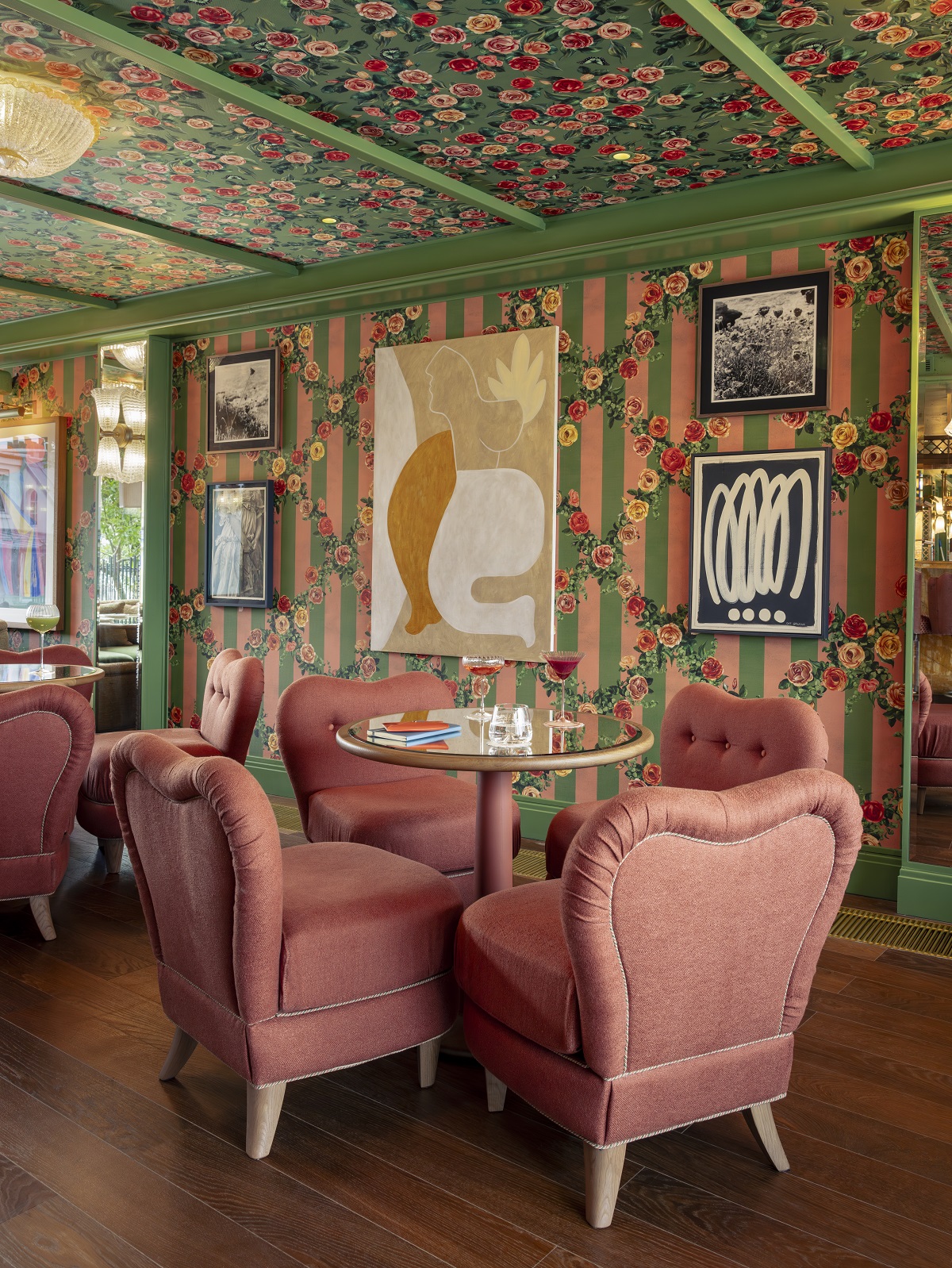 pink and green striped and floral wallcovering and pink chairs in dining area