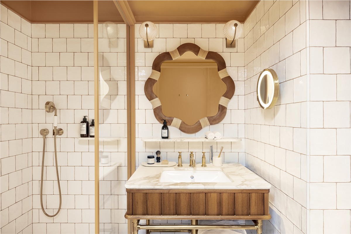 shower and vanity with scalloped round mirror above basin