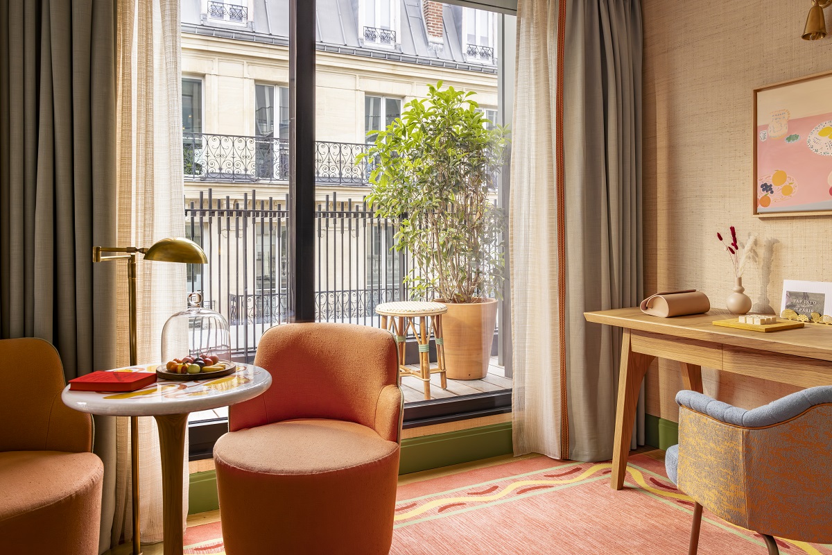 chair and table in guest suite with views over Paris street