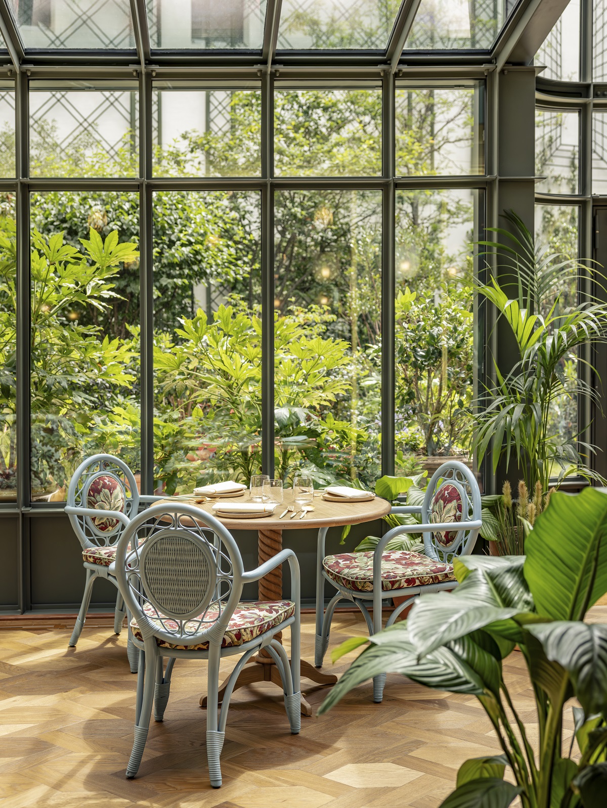 table chair and plants with floor to ceiling window in paris hotel