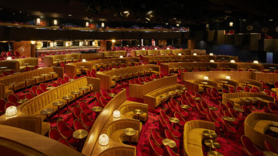 Gold, theatre style seating in a Parisian cabaret hall, with geometric red patterned carpets by Ege Carpets