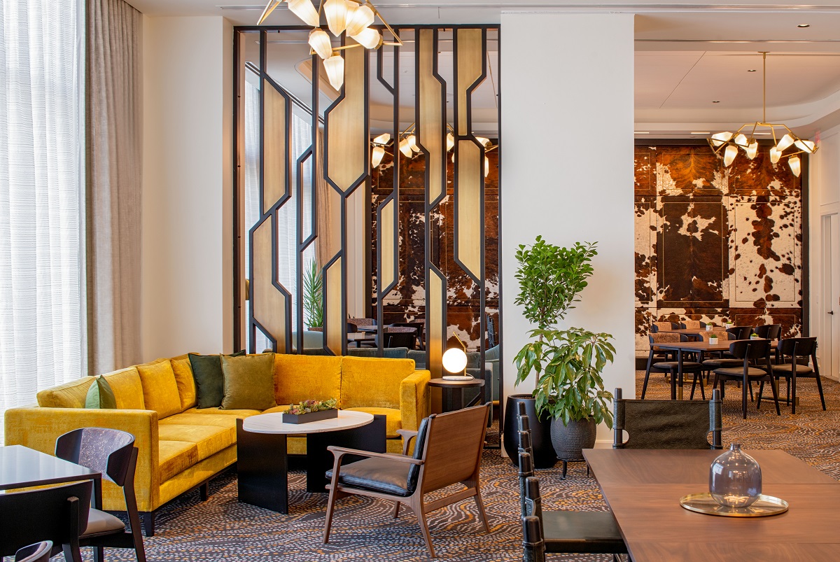 yellow seating in front of art deco glass screen in Hilton Tempo Nashville