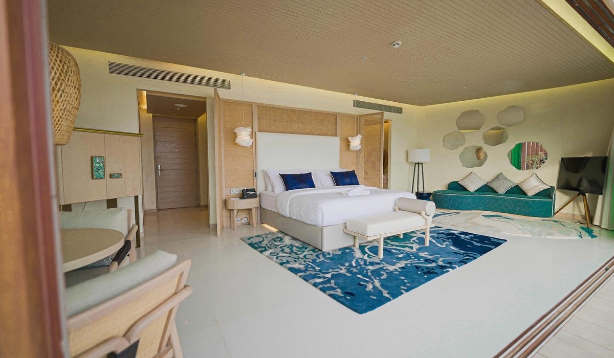 bed on blue carpet and stone floor in guestroom at Tawila Island Resort