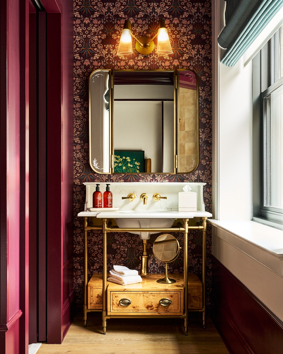 vintage style bathroom with floral wallpaper behind the basin