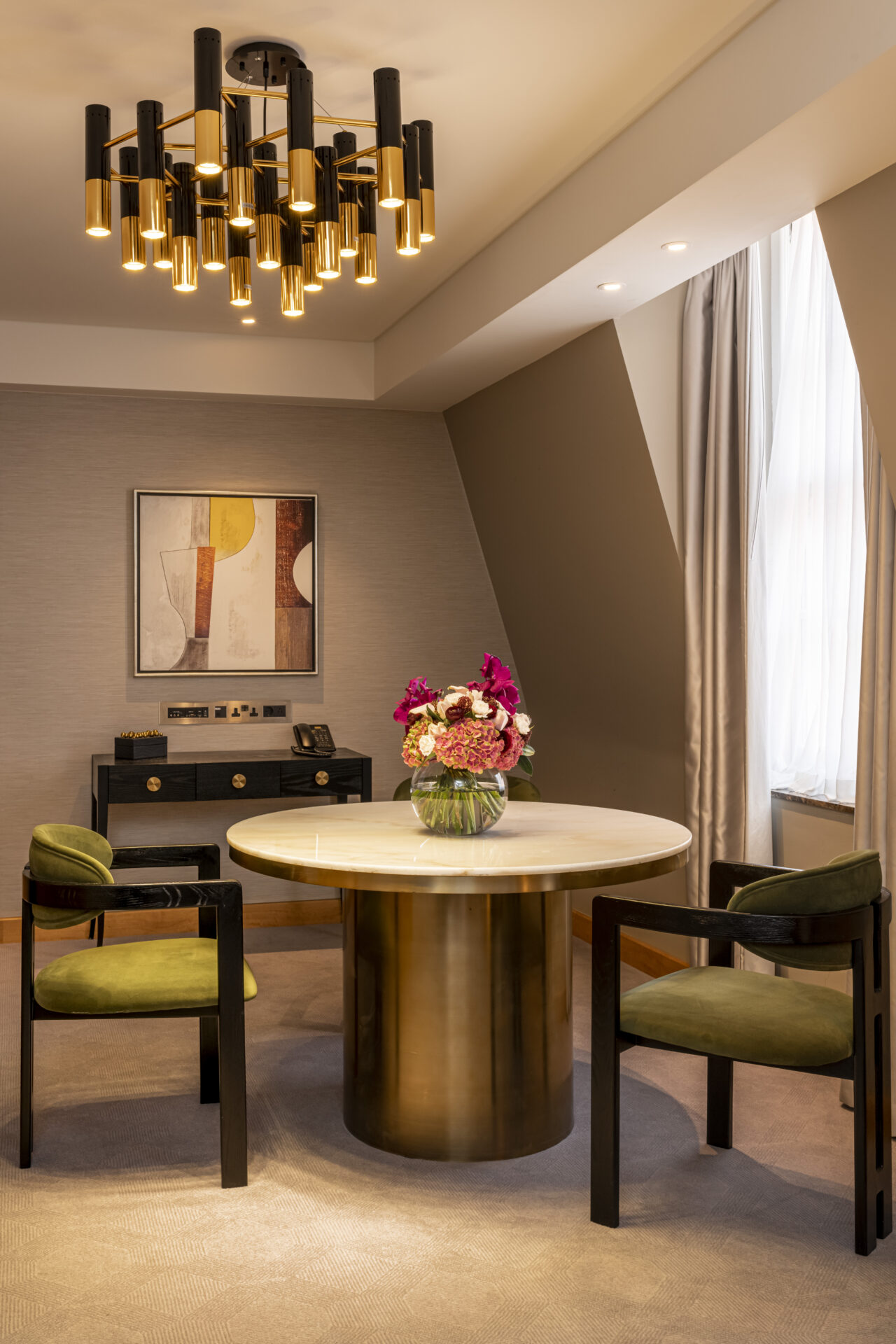 neutral toned dining area with green seating and marble circle table. Liang & Eimil surfaces