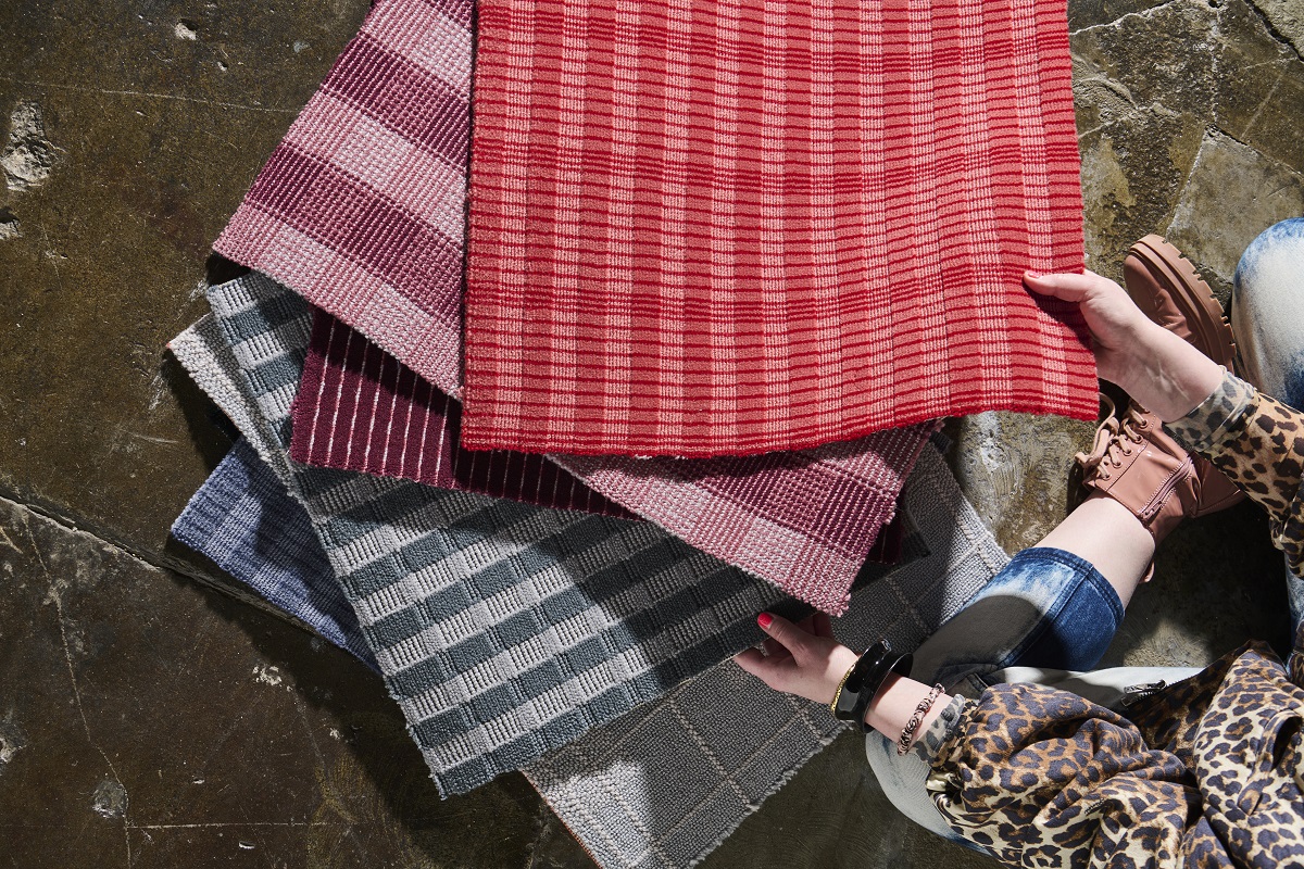 person seated on the floor sorting through carpet samples