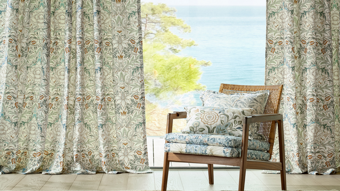 chair in william morris fabric in front of curtains and sea view