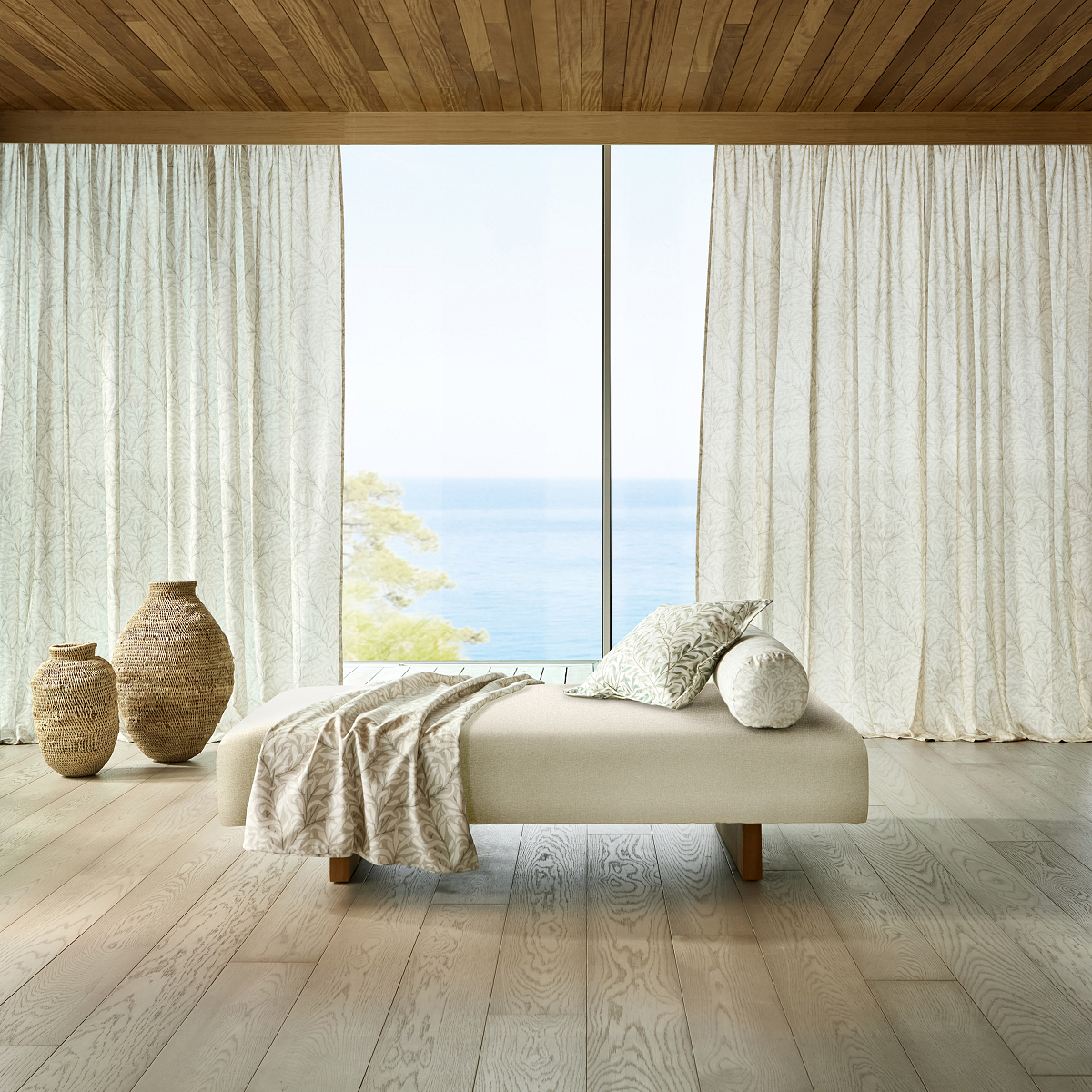 low bench seating in front of full length window and curtains with sea view