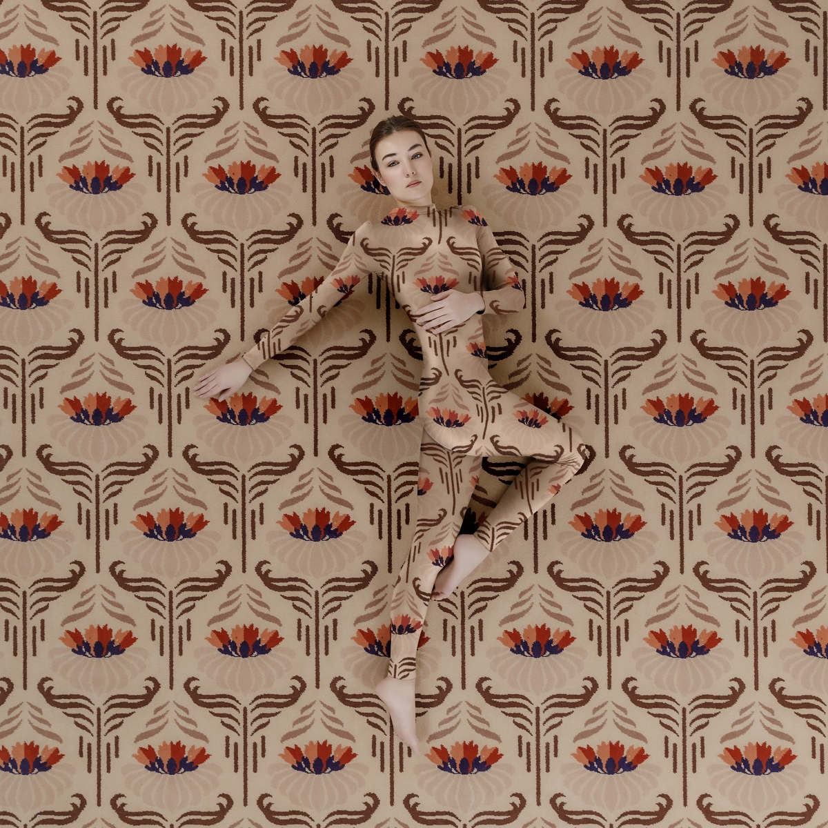 model posing on patterned carpet in body suit of same pattern