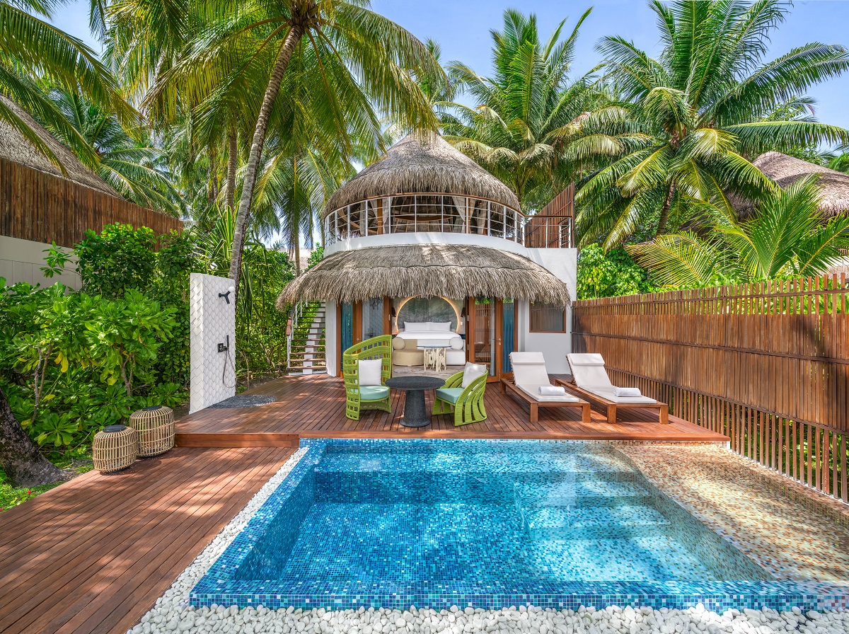 private swimming pool in beach villa with loungers and palm trees