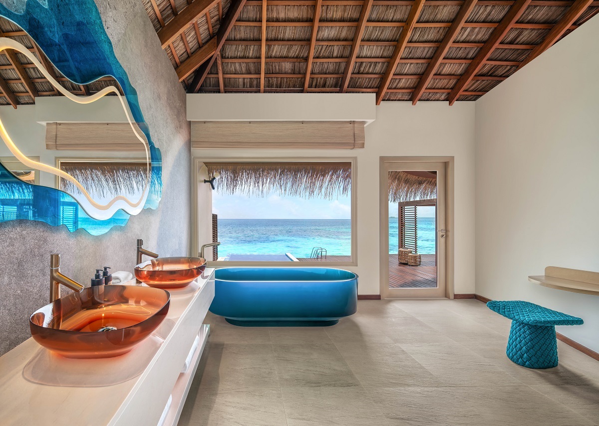 blue wave mirror above orange glass basin with blue bath overlooking the ocean