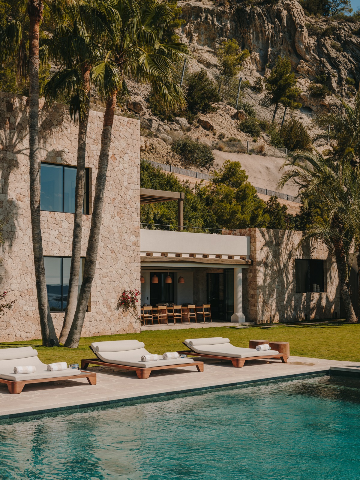 palm trees, pool and sunloungers in Ibiza villa