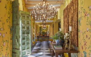 yellow patterned wallpaper, checked floor and chandelier in maximalist interior of Franschoek House Royal Portfolio