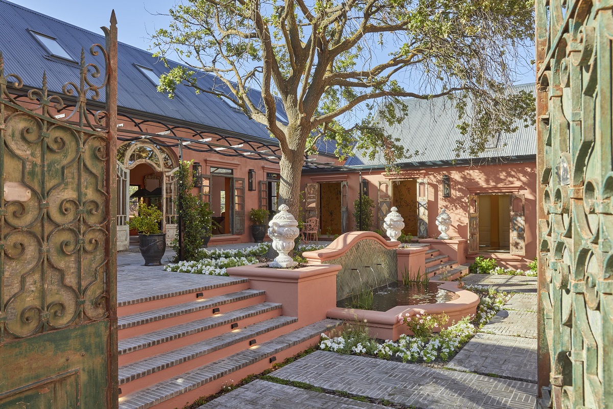 pink walls and olive green details and gate in entrance to Franschoek House