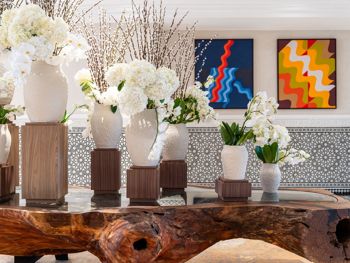 floral display on wooden table with contemporary art on wall behind