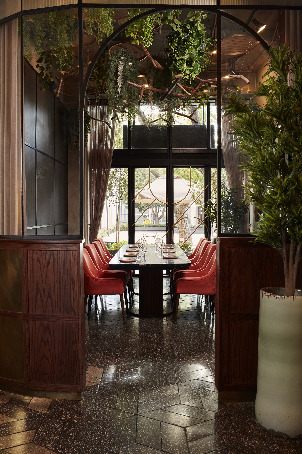 dining table under sculptural light in front of window with street view