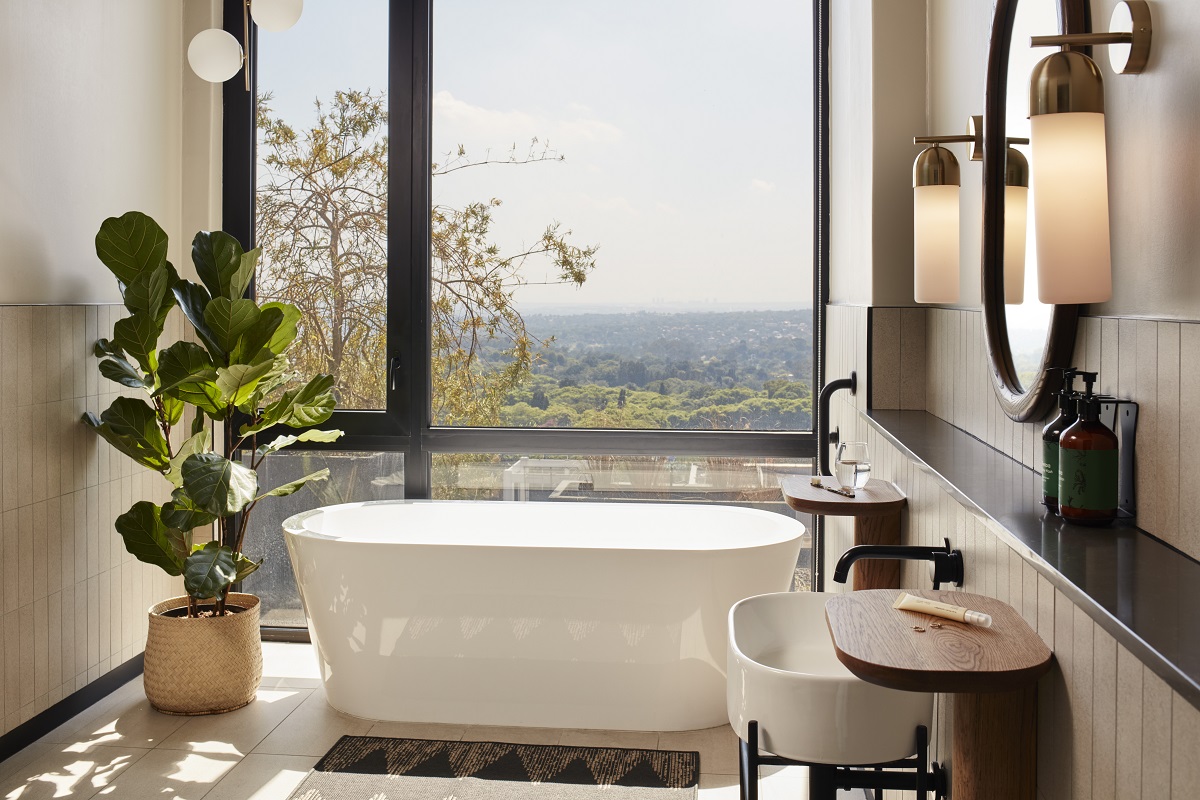 freestanding bath, plant and view over Jo'burg in HYDE Jo'burg