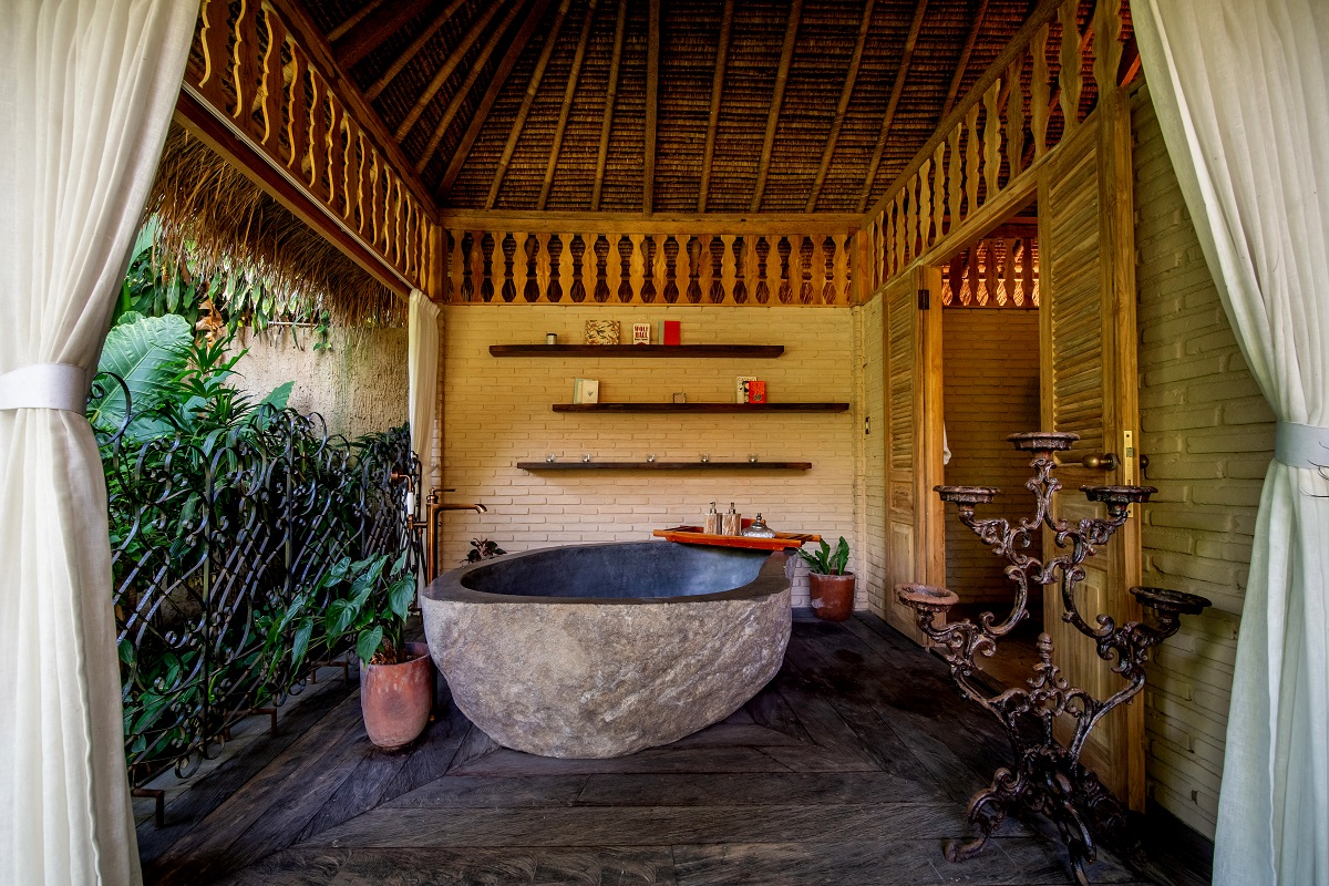 indoor-outdoor bathroom with stone bath