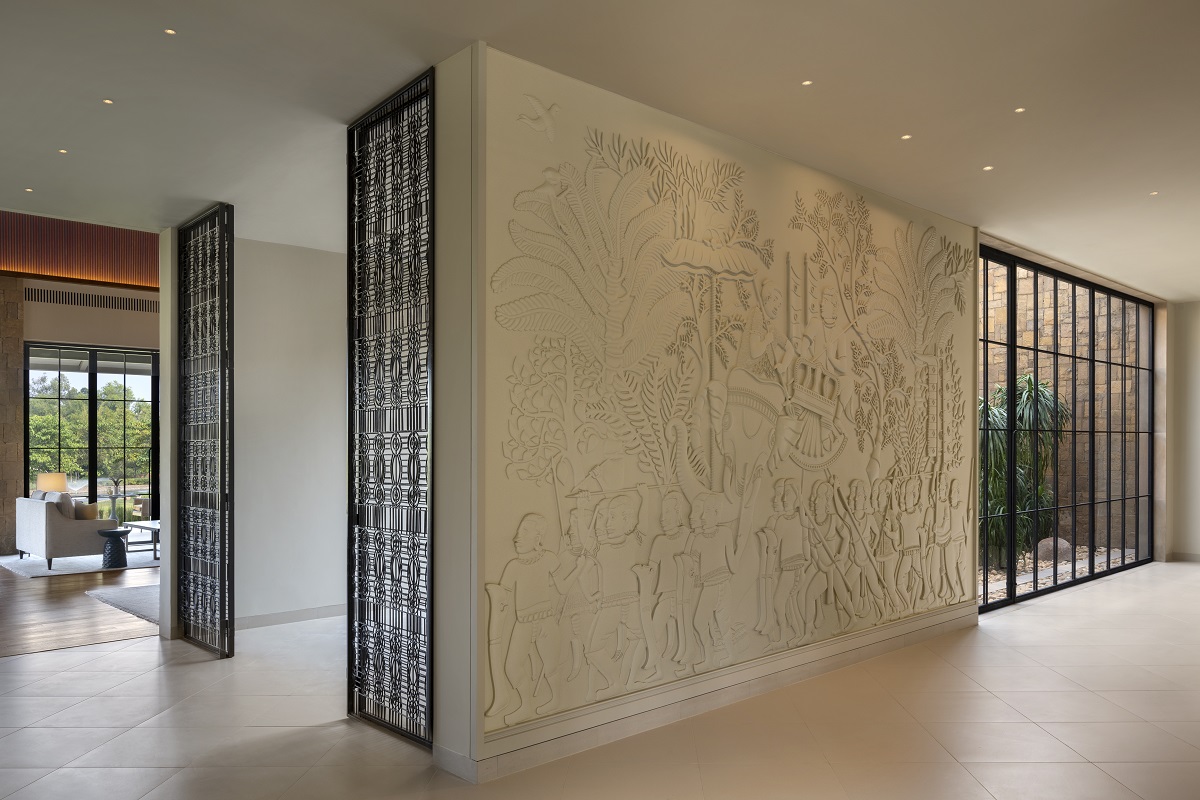 sculptural stone panel on wall in the hotel entrance depicting a Baiga tribe procession