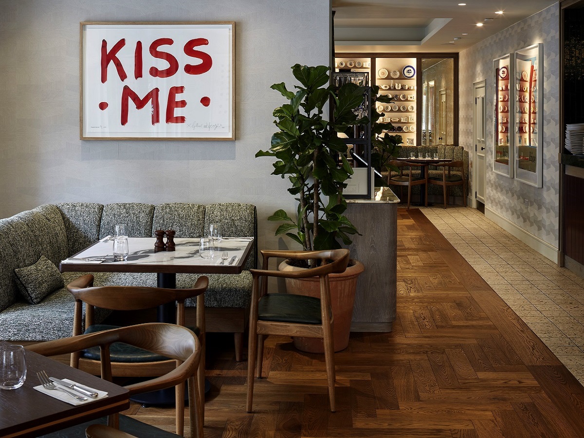 restaurant seating and corner banquette with Kiss me typographic poster