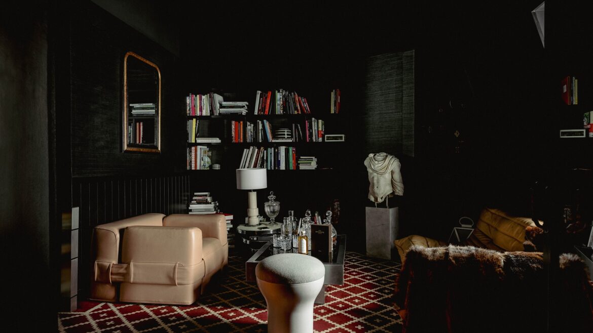 black interior with bookshelves and cream seating in The Experimental Marais