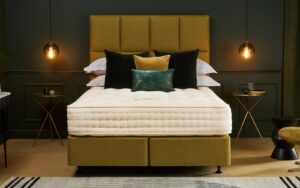 Chartreuse bed and headboard with Hypnos mattress, in dark coloured bedroom with low lighting from pendants either side of bed