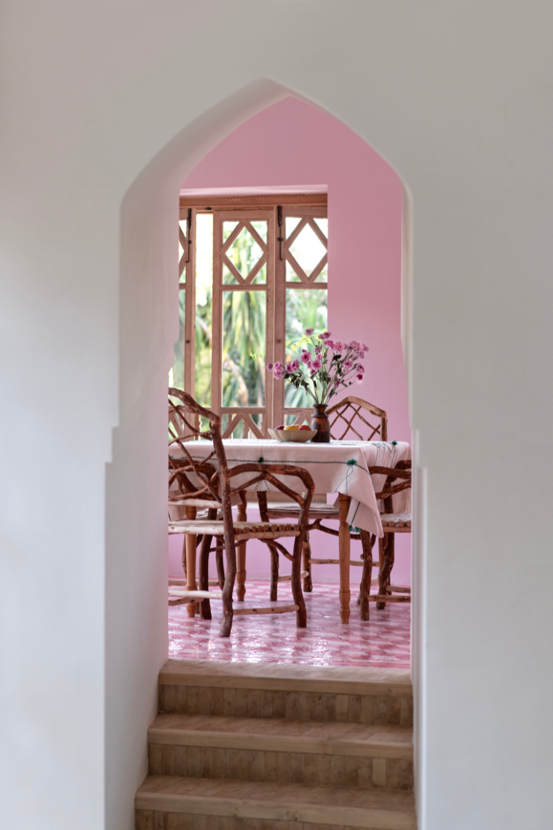 Shot through arched doorway into pink walled dining area at Jnane Rumi