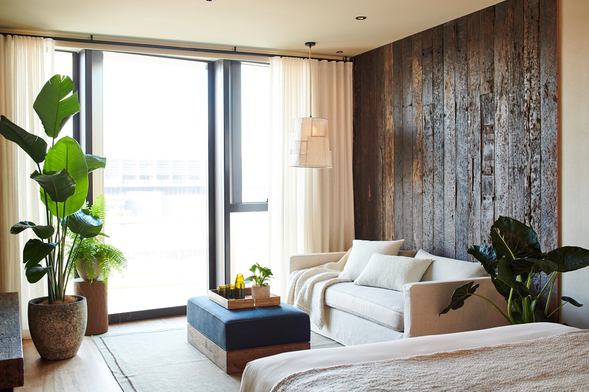 reclaimed wooden wall panelling, cream furniture and plants in 1 Hotel Melbourne